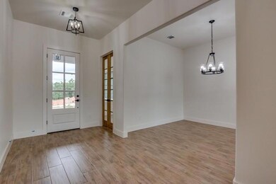 Foyer with a chandelier, light wood-type flooring, and baseboards