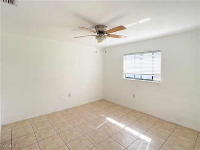Empty room featuring tile patterned flooring and ceiling fan