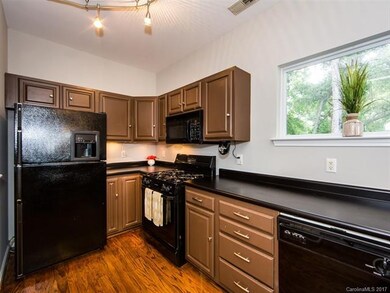 Kitchen features maple cabinets, black appliances 