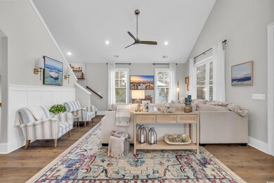 Living room featuring ceiling fan, dark hardwood /