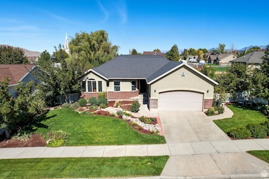 Ranch-style home featuring an attached garage, concrete driveway, brick siding, and stucco siding
