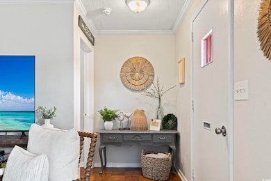 Hallway with a textured ceiling and crown molding