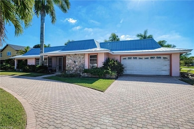 Ranch-style home with stucco siding, decorative driveway, a garage, a metal roof, and a front yard
