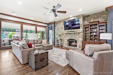 Living area featuring a ceiling fan, a stone firep