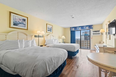 Bedroom featuring access to outside, a textured ceiling, hardwood / wood-style floors, and a wall mounted AC