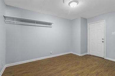 Empty room with dark hardwood / wood-style floors