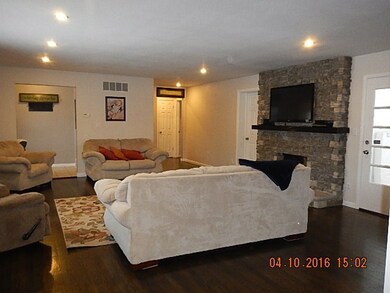 LARGE LIVNG ROOM WITH HARDWOOD FLOORING AND BEAUTIFUL STONE FIREPLACE
