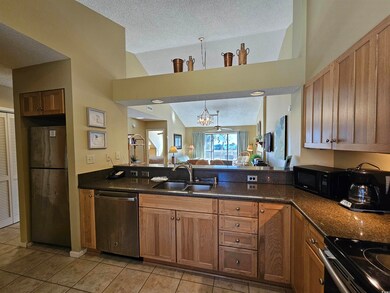 Kitchen with sink, vaulted ceiling, a textured cei