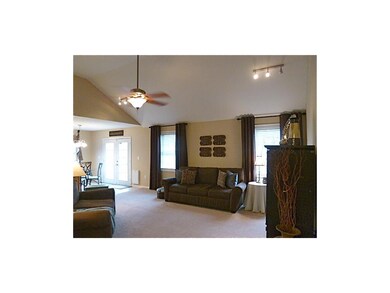 Open living area with vaulted ceiling, ceiling fan