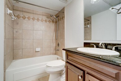 En suite bathroom with granite counter.