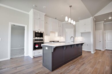 Kitchen featuring an island with sink, stainless s