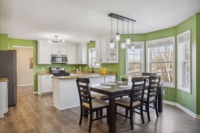 Informal dining room with upgraded lighting  and huge bay window.