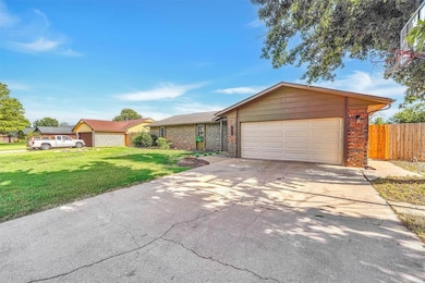 Single story home featuring an attached garage, concrete driveway, and brick siding