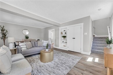 Living room featuring hardwood / wood-style flooring, crown molding, and built in features