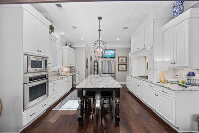 Kitchen with white cabinets, built in appliances, 