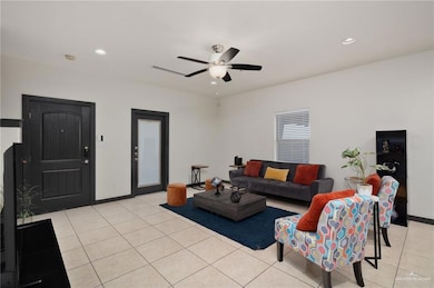 Living room with ceiling fan, baseboards, light tile patterned flooring, and recessed lighting