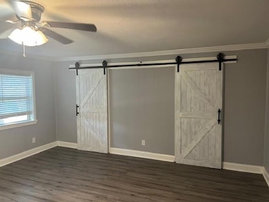 Unfurnished bedroom featuring ceiling fan, a textu