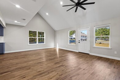 Unfurnished living room featuring high vaulted ceiling, dark wood-style flooring, recessed lighting, and a ceiling fan