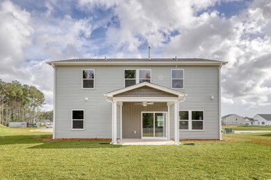 Back of property featuring ceiling fan, a yard, an