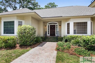 Lovely entryway is flanked by two bay windows and 