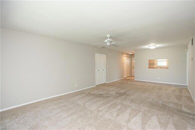 Empty room with ceiling fan and light colored carp