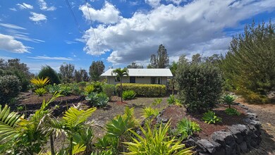 Tropical landscaping surrounds this single-level home. Private, peaceful setting with mature plants and stone accents, perfect for island living.