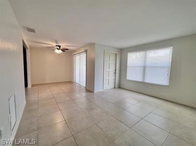 Tiled spare room with a ceiling fan