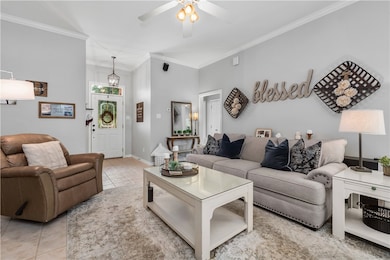 Living room featuring crown molding, light tile pa