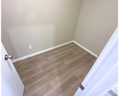 Bathroom featuring dark wood-style floors and baseboards