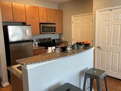 Kitchen featuring dark wood-style floors, brown c