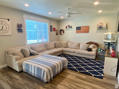 Living room with recessed lighting, wood finished floors, and ceiling fan
