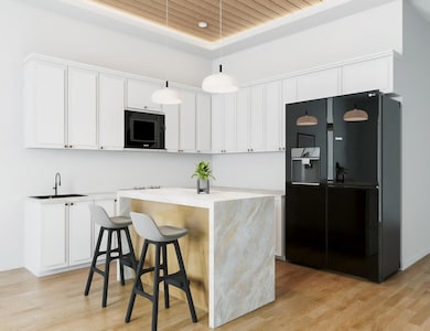 Kitchen featuring black appliances, white cabinet