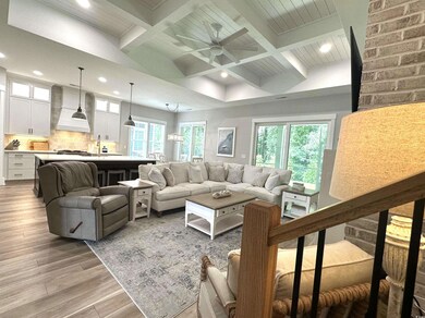 Living room featuring beamed ceiling, light hardwo