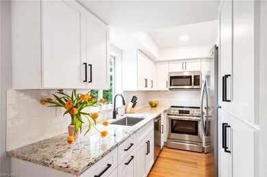 Kitchen featuring appliances with stainless steel finishes, white cabinets, light wood finished floors, backsplash, and recessed lighting
