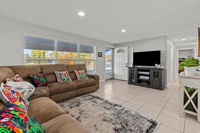 Living room featuring light tile patterned flooring and recessed lighting