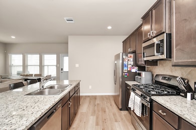 Kitchen features tons of cabinet space, a gas stove, and island with additional seating.