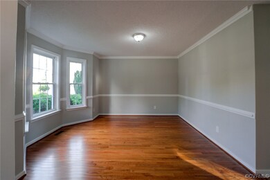 Spare room featuring crown molding, dark hardwood