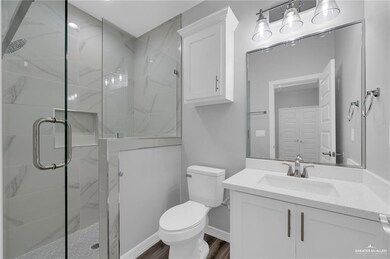 Bathroom with a shower stall, vanity, and wood finished floors