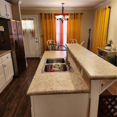 Kitchen featuring ornamental molding, refrigerator