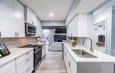 Kitchen featuring sink, ceiling fan, white cabinet
