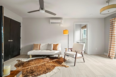 Living room featuring ceiling fan, baseboards, an