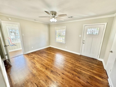 Living room with ceiling fan, dark hardwood and cr