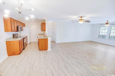 Kitchen with black electric range, brown cabinets, open floor plan, and light wood finished floors
