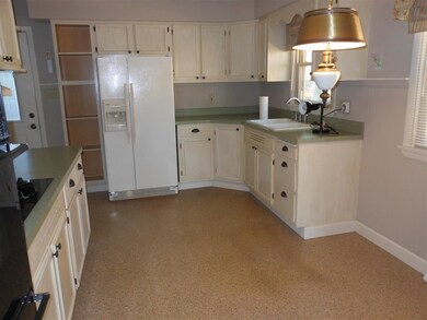 Kitchen has laminate flooring, an abundance of cab
