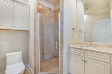 Bathroom featuring toilet, ornamental molding, wal