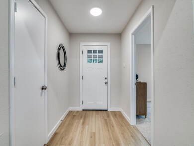 Doorway with light hardwood / wood-style floors