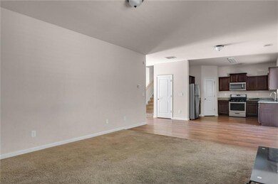 Unfurnished living room featuring carpet floors and sink