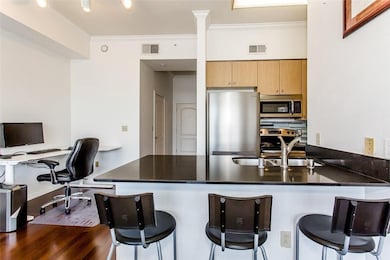 Kitchen with ornamental molding, a kitchen bar, appliances with stainless steel finishes, a peninsula, and a desk