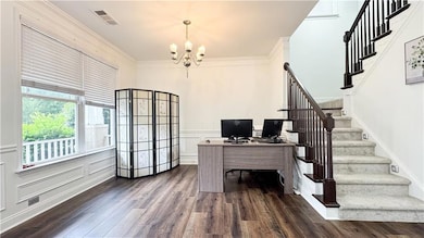 Home office featuring a chandelier, dark wood-type