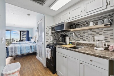 Kitchen featuring black electric range oven, a sink, open shelves, light wood-type flooring, and decorative backsplash